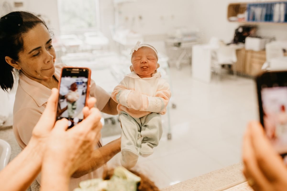 Nurse presenting a newborn baby to the family